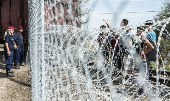Police on the Hungarian side facing migrants stranded on the Serbian side of the border fence | Sándor Ujvári / MTI